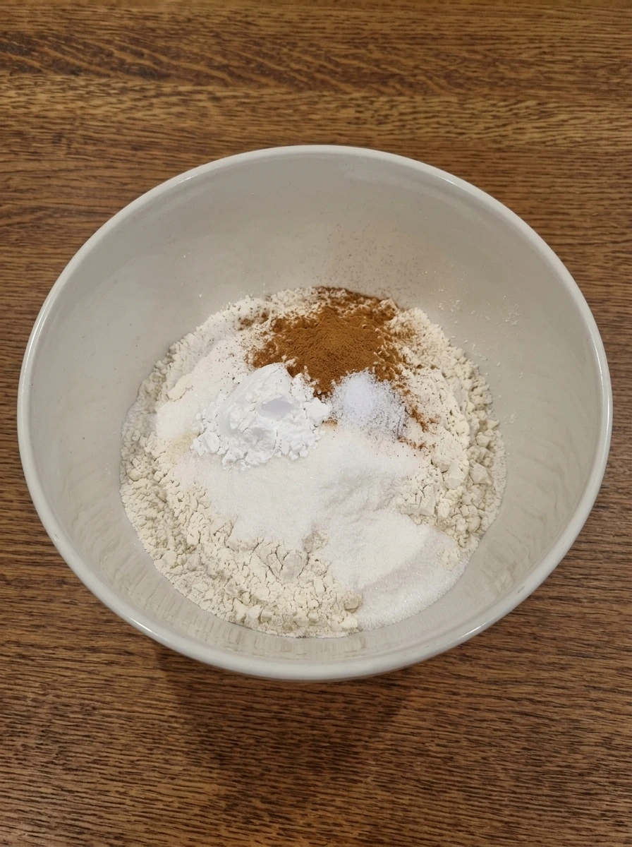 Dry ingredients measured in a white ceramic mixing bowl for blueberry muffins
