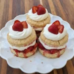 Classic strawberry shortcake served on a white scalloped dessert plate
