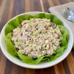Creamy tuna salad served on a white stoneware plate with lettuce and dill