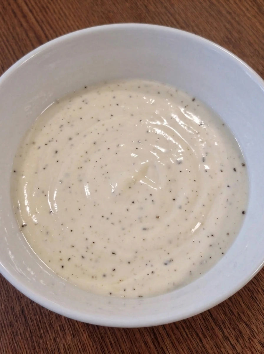 Smooth creamy tuna salad dressing in a white ceramic bowl