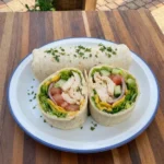 Easy chicken wrap sliced and served on a white plate with blue rim