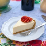 Easy no bake cheesecake with strawberry topping on a white scalloped ceramic dessert plate