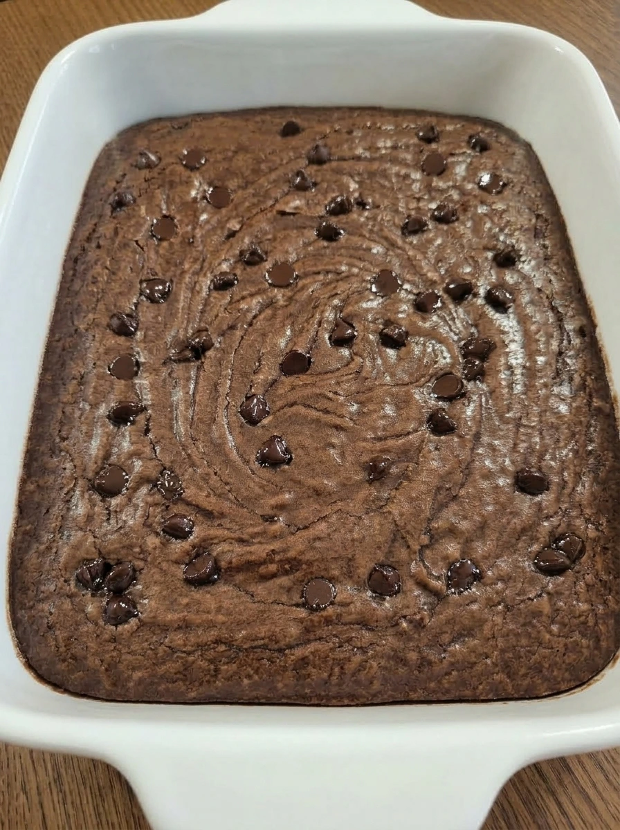 Cooled brownies with crackly top in a white ceramic dish