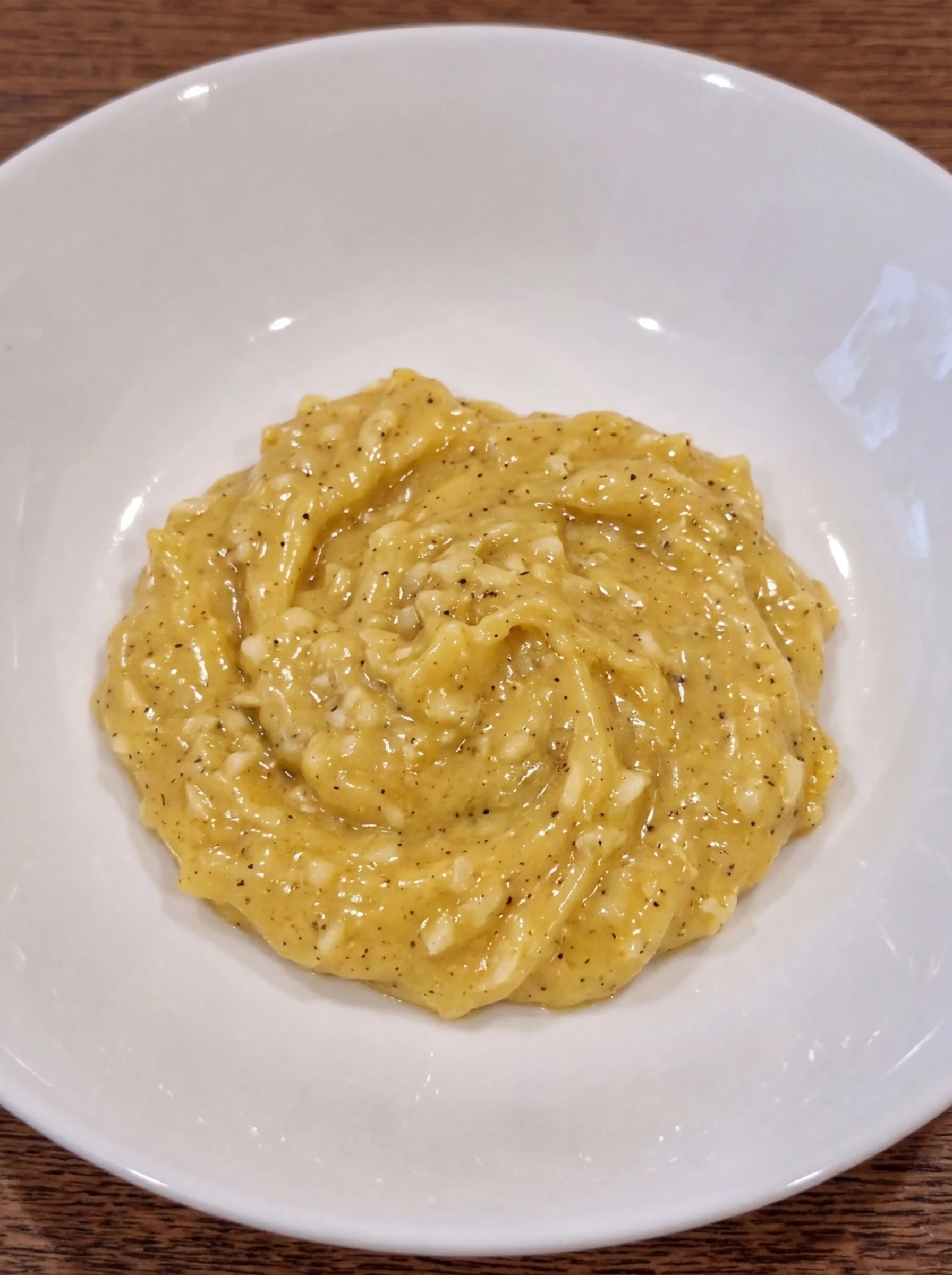 Uncooked garlic butter seasoning mixed in a white ceramic pasta bowl