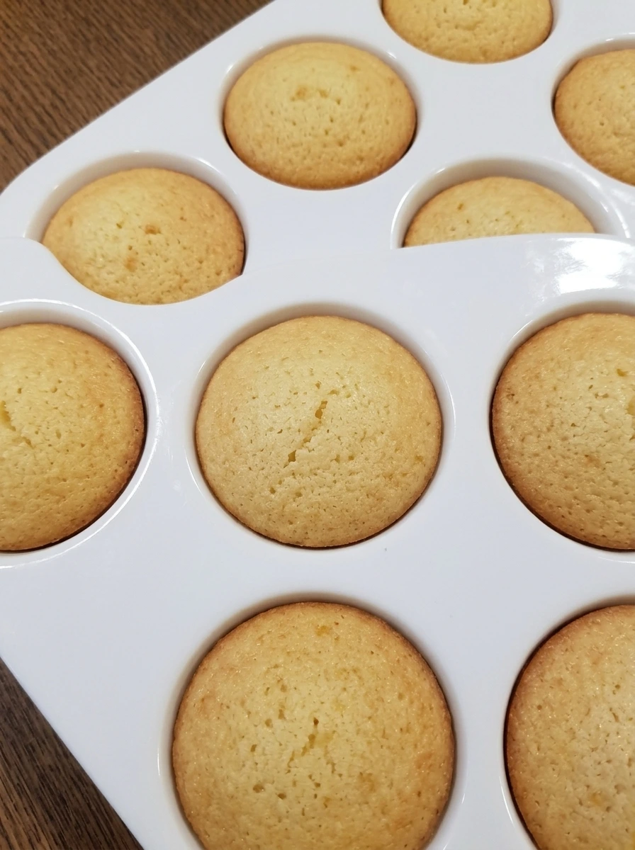 Baked mini lemon cakes cooling in white ceramic tray