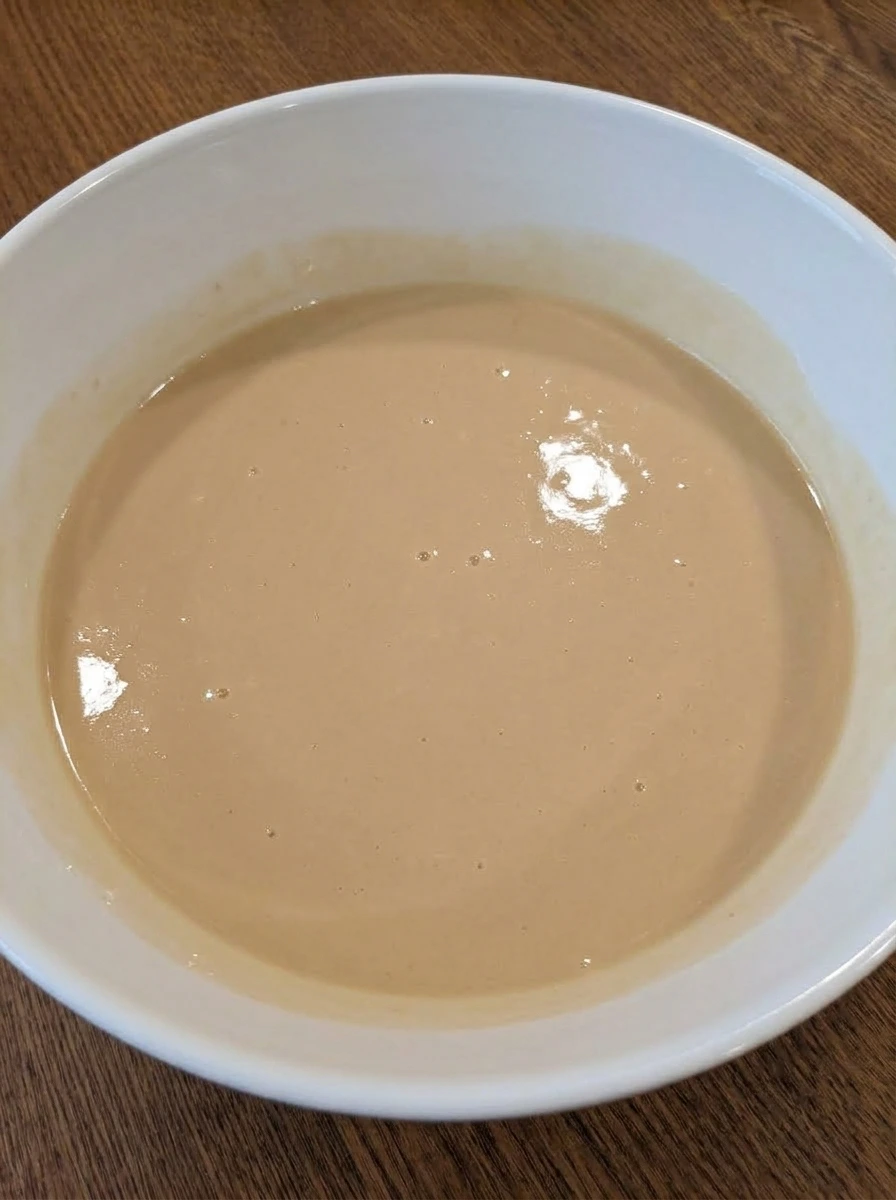 Wet ingredients whisked together in a white ceramic bowl