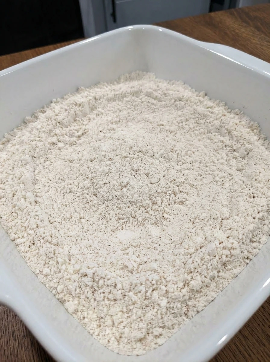 Whisked dry biscuit mixture in a white ceramic baking dish