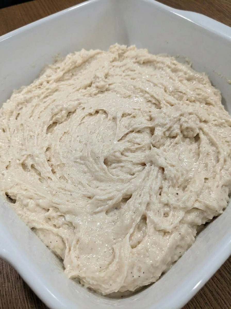 Shaggy biscuit dough mixed in a white ceramic baking dish