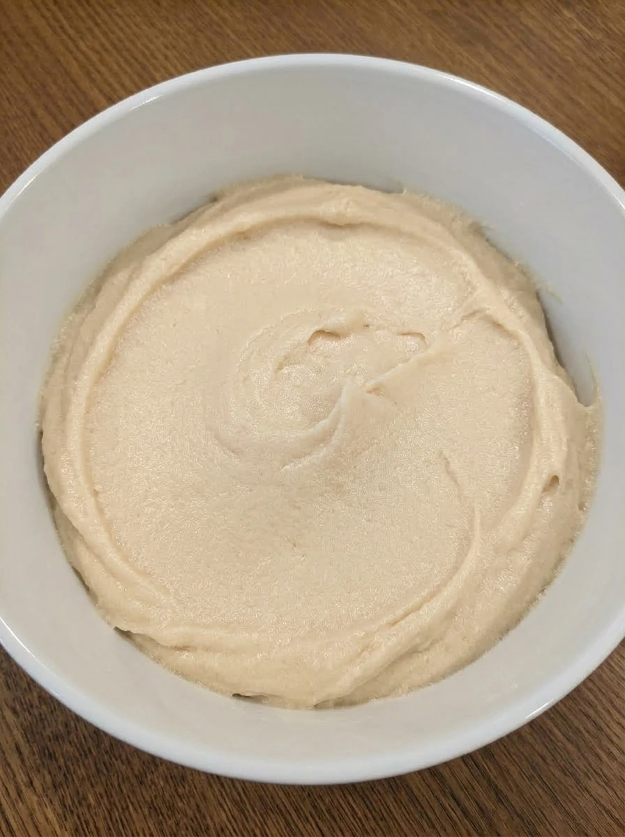 Butter and sugars creamed in a white ceramic bowl