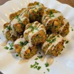 Baked Falafel with Tahini Sauce on a white plate with uneven golden browning and chopped parsley.