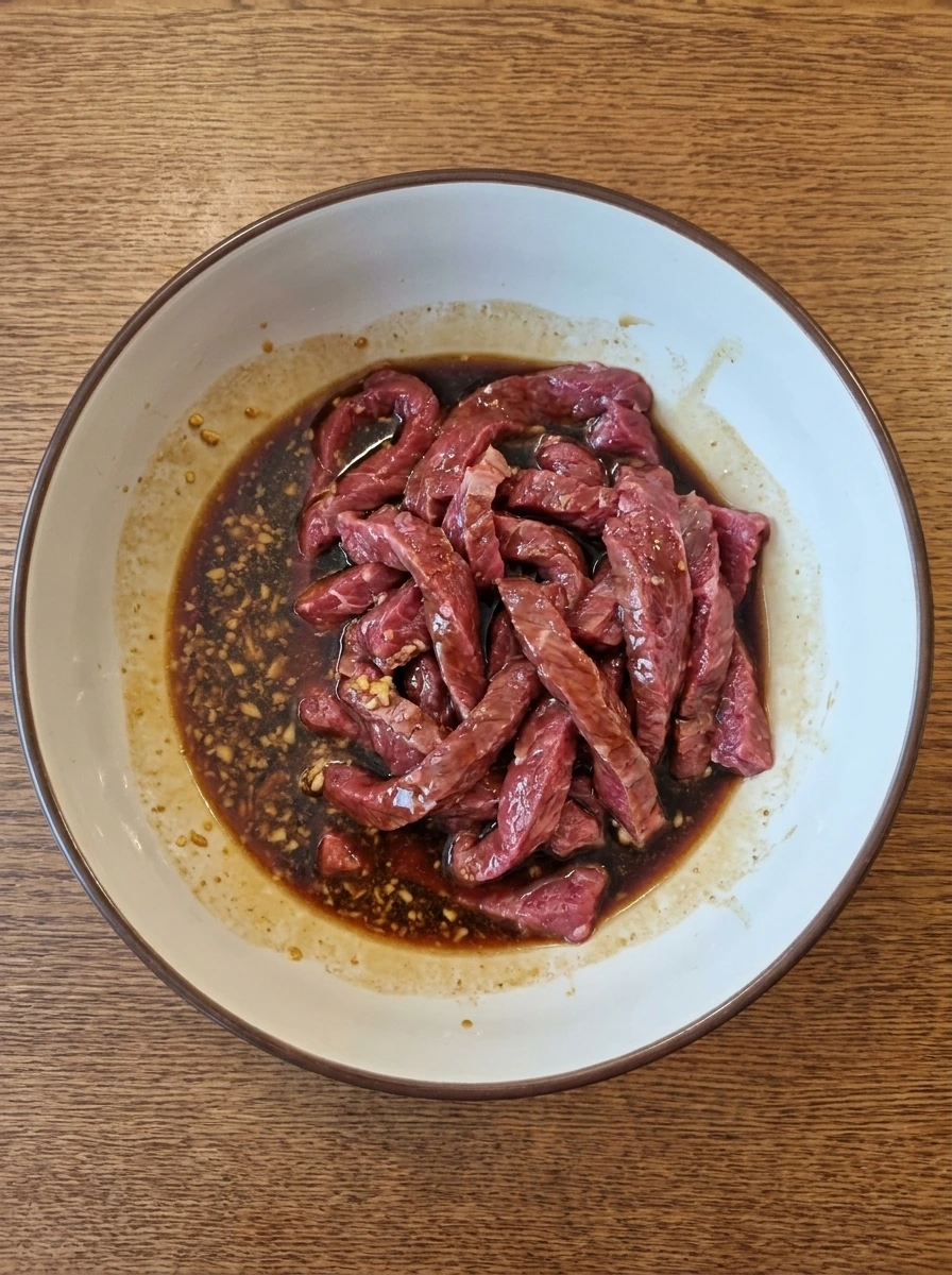 Sliced beef coated with sauce mixture for Beef and Broccoli.