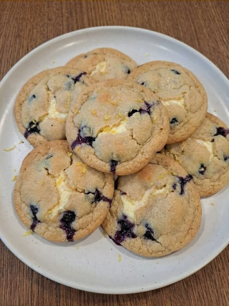 Blueberry Cheesecake Cookies on a matte white stoneware dessert plate with golden edges and creamy swirls.