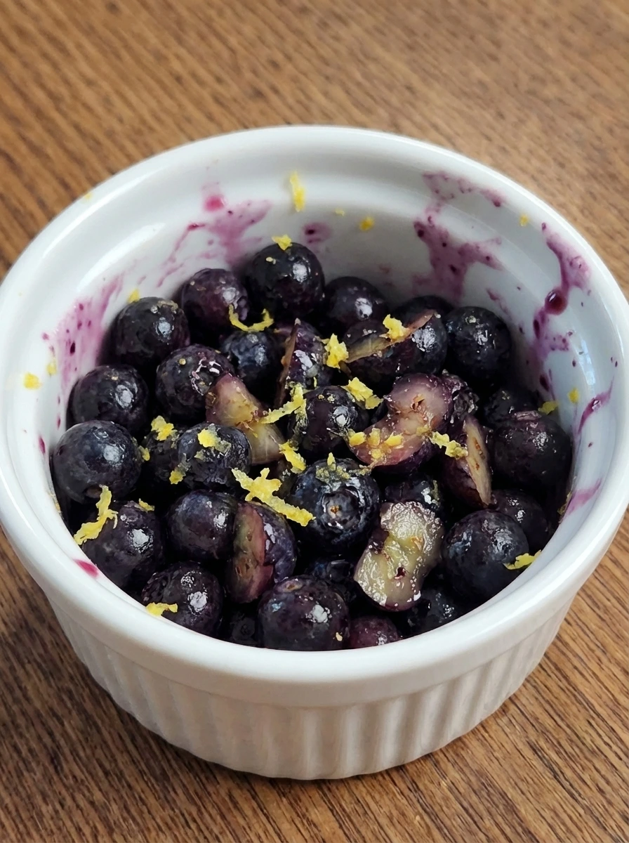 Blueberries chopped and mixed with lemon zest in a bowl.