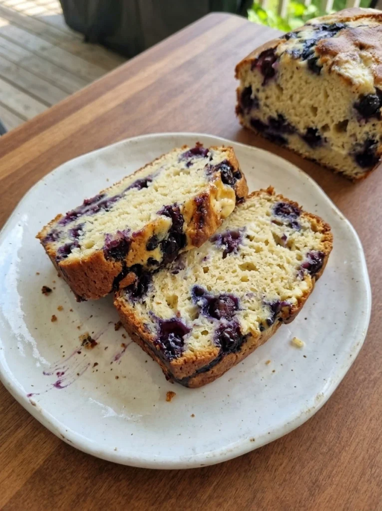 blueberry cream cheese bread sliced with golden crust and creamy swirls