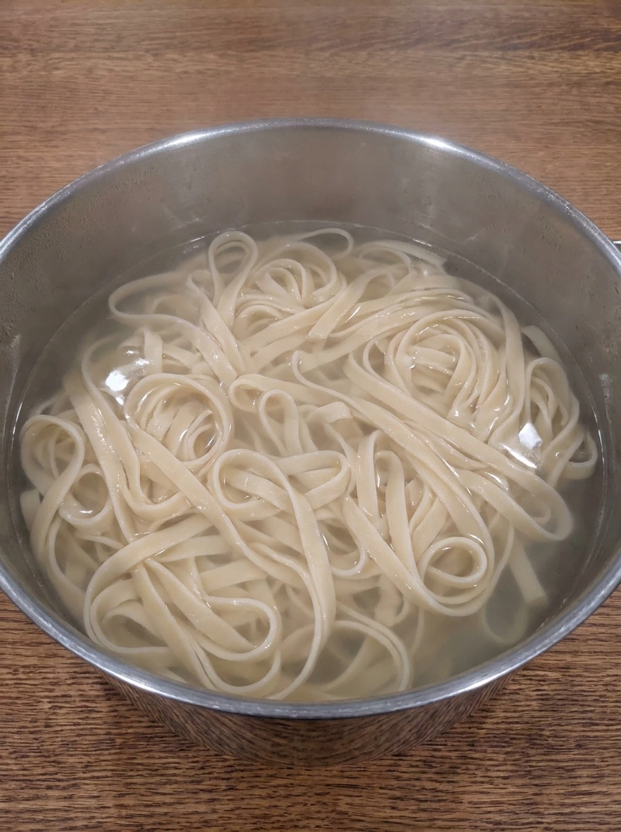 Tender fettuccine cooking for Cajun Shrimp Pasta.