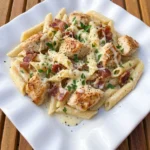 Chicken Bacon Ranch Pasta served on a white plate with creamy sauce sliced chicken crispy bacon and melted cheese