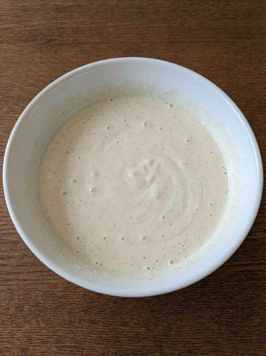 Wet pancake ingredients whisked smooth in a white bowl