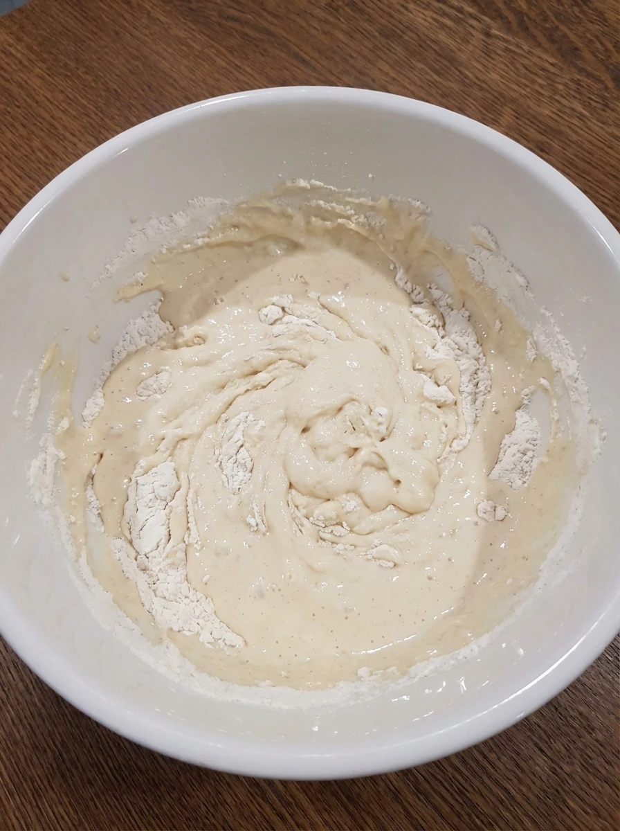 Pancake batter partially mixed with visible flour streaks