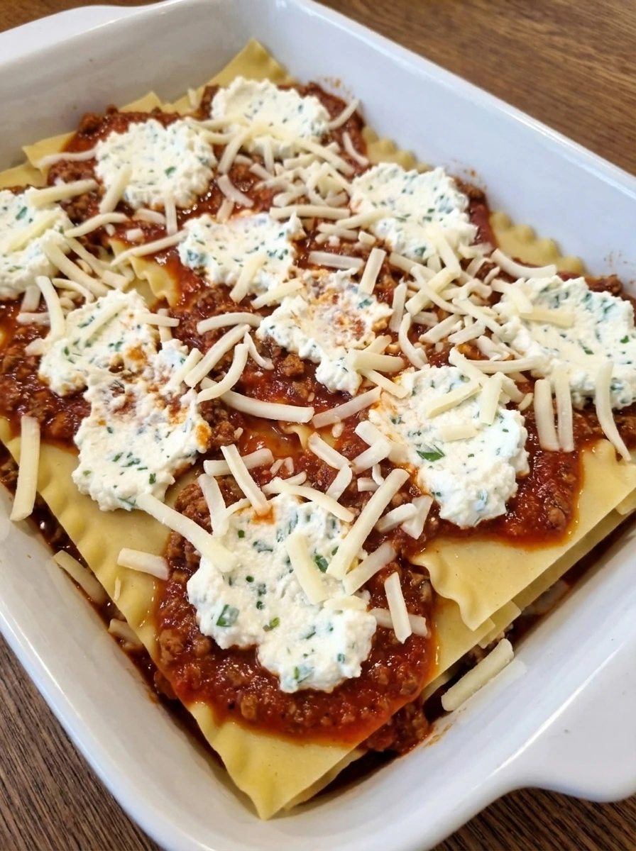 Layered lasagna with sauce ricotta and mozzarella in a natural white dish