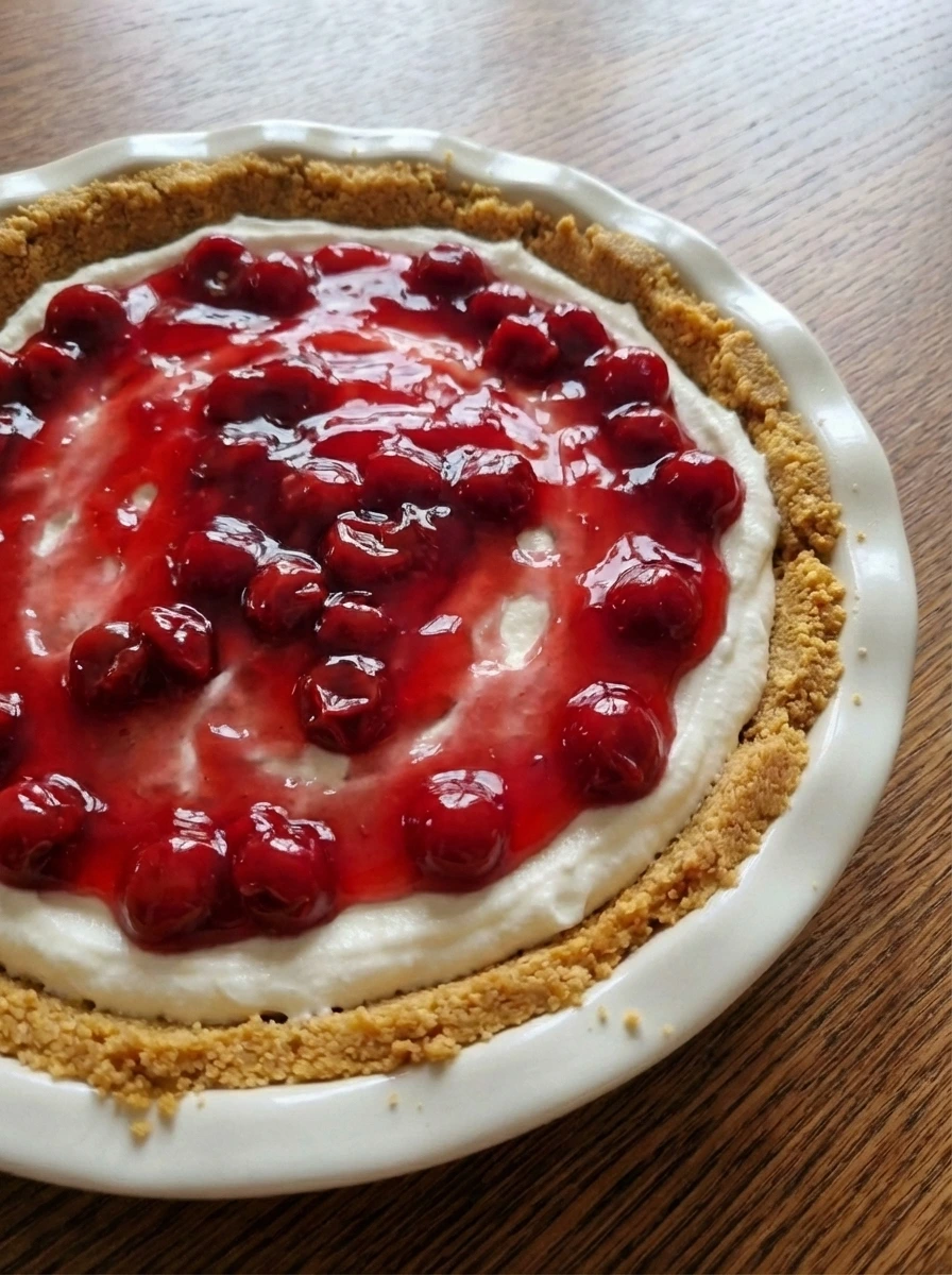 Glossy cherry topping loosely spooned over cream layer