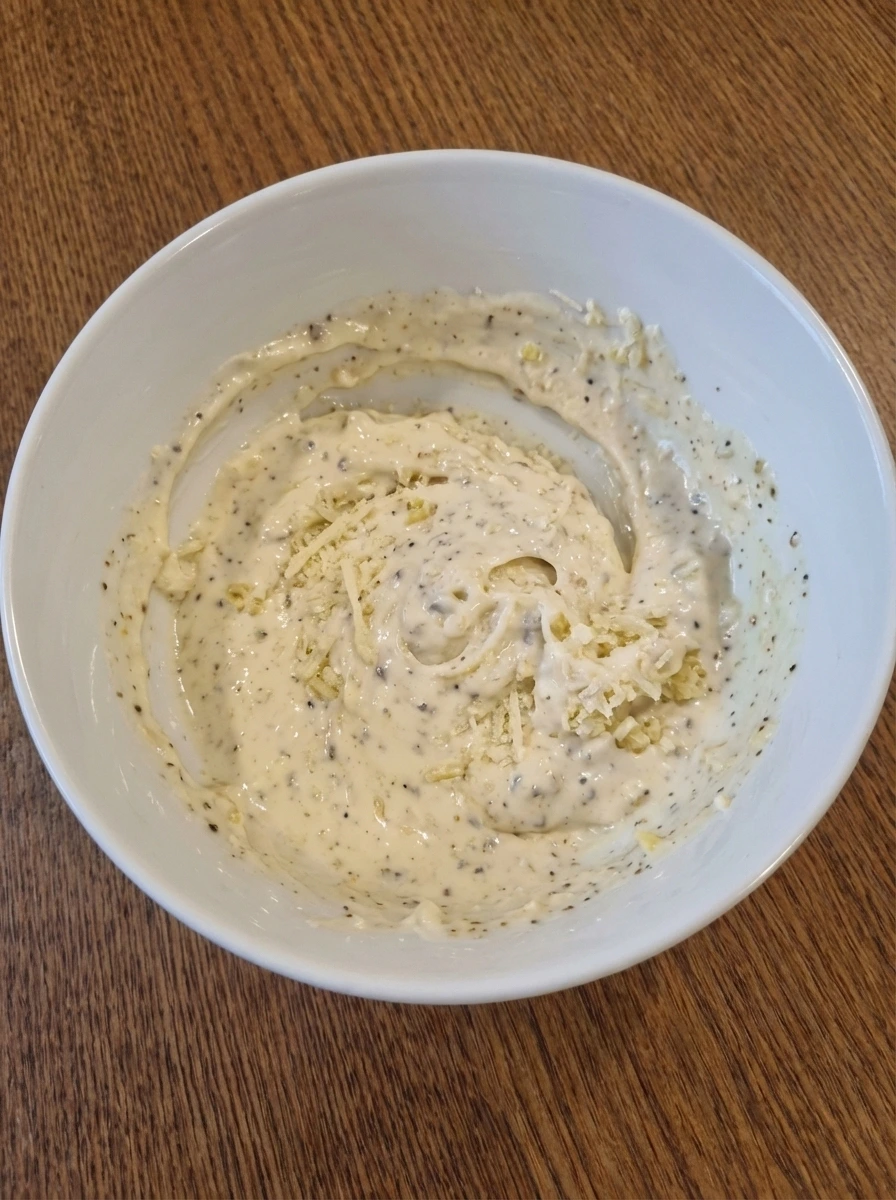 Creamy homemade Caesar dressing mixed in a white bowl