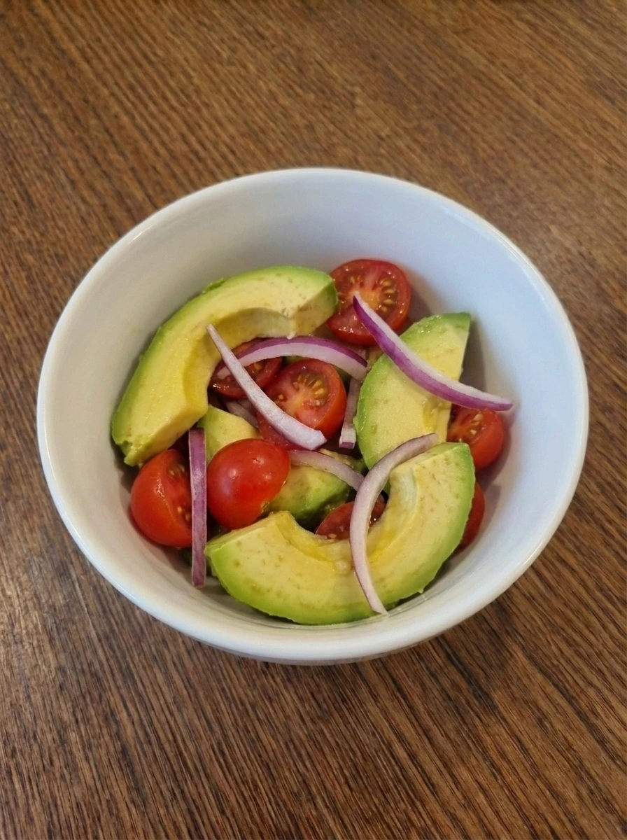 Sliced avocado tomatoes and red onion for Cobb Salad