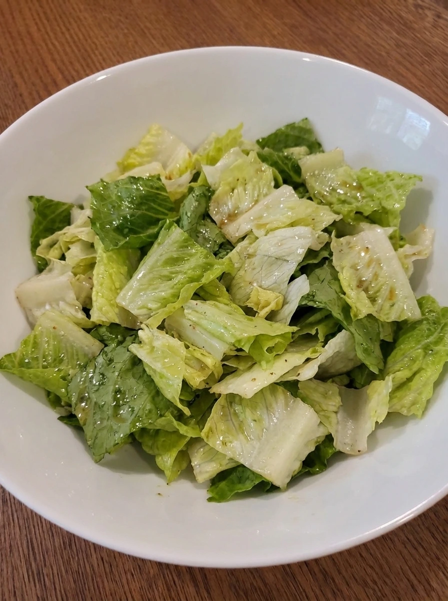 Lettuce tossed with dressing for Cobb Salad