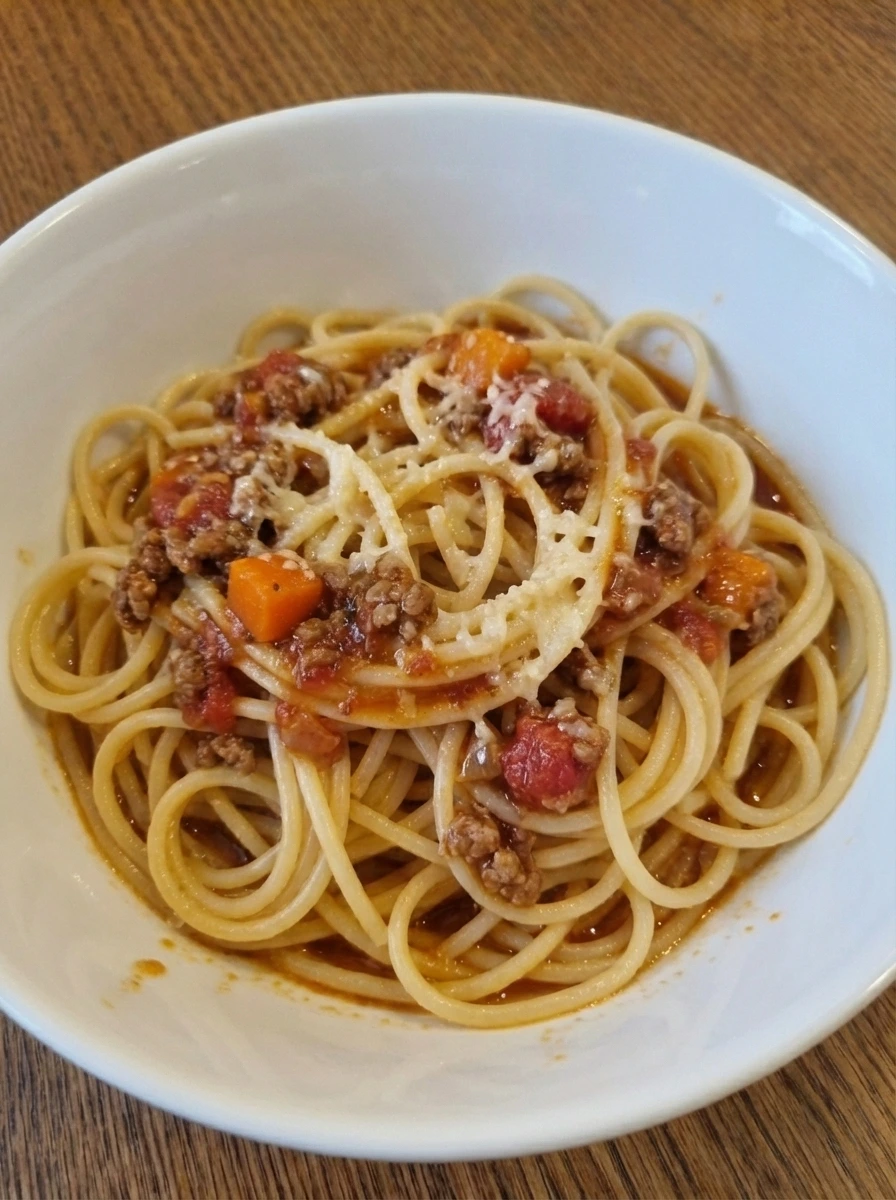 Spaghetti tossed with thick Bolognese sauce and Parmesan