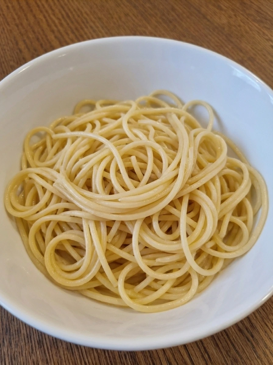 Tender cooked spaghetti loosely piled in a bowl