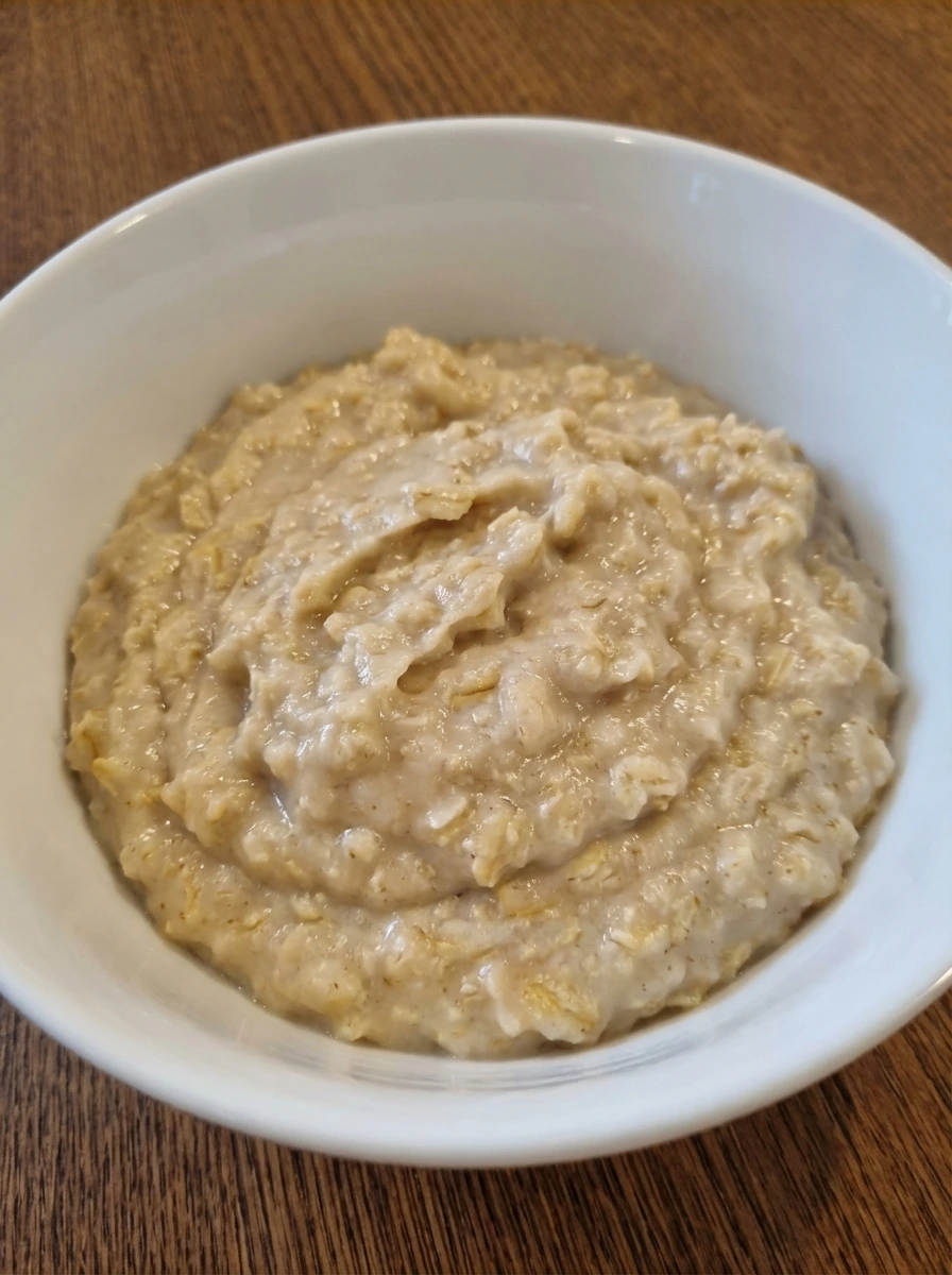 Creamy thick oatmeal with soft folds in a natural white dish