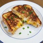Crispy Grilled Cheese Sandwich on a white plate with golden bread and melted cheese
