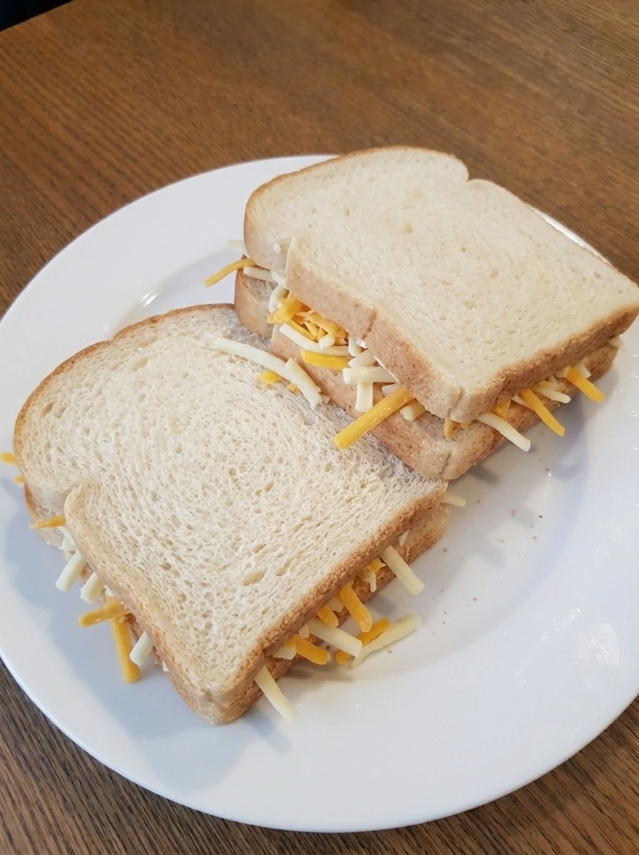 Assembled grilled cheese sandwiches with loose cheese filling