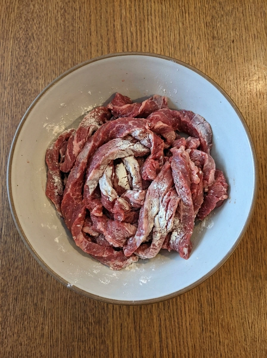 Sliced flank steak coated with cornstarch for Crock Pot Beef and Broccoli