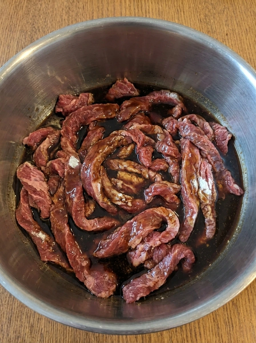Beef covered with sauce before slow cooking for Crock Pot Beef and Broccoli