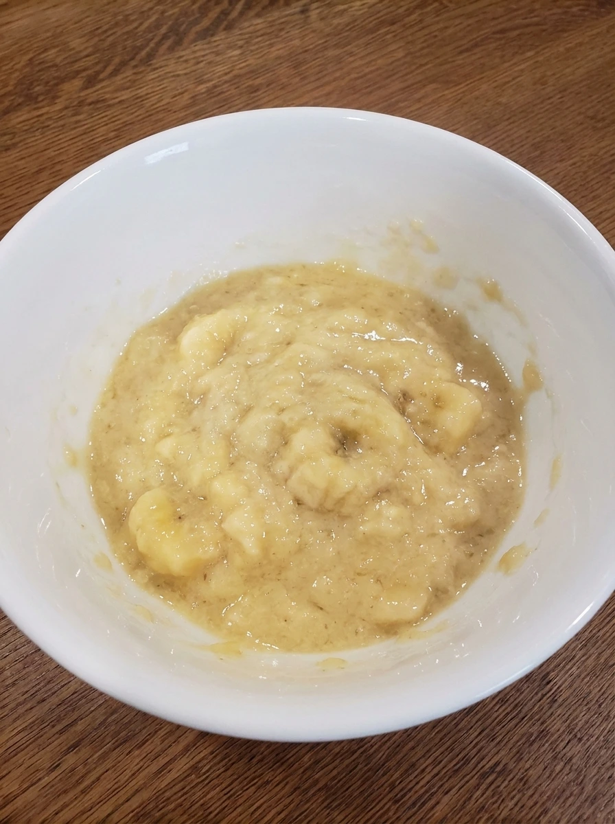 Mashed ripe bananas in a bowl for Easy Banana Bread.