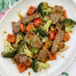 Easy Beef Stir Fry plated on a white oval stoneware plate with glossy sauce and tender vegetables