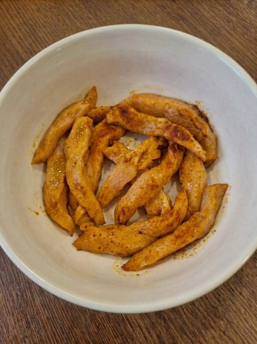 Cooked chicken strips with slight browning for wraps