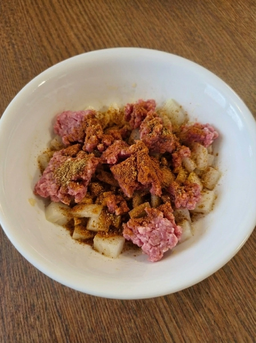 Raw ground beef coated with taco seasoning for Easy Ground Beef Tacos