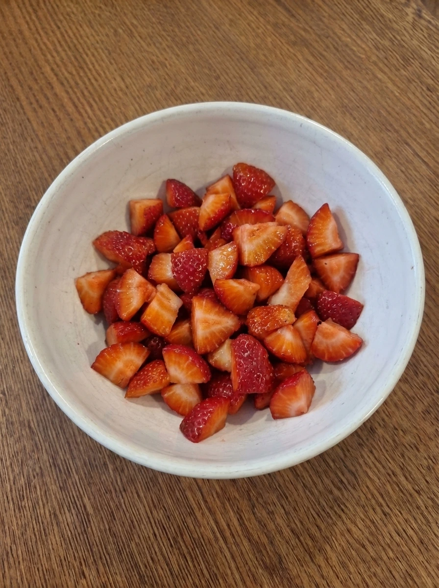 Chopped strawberries in a white bowl for muffin batter