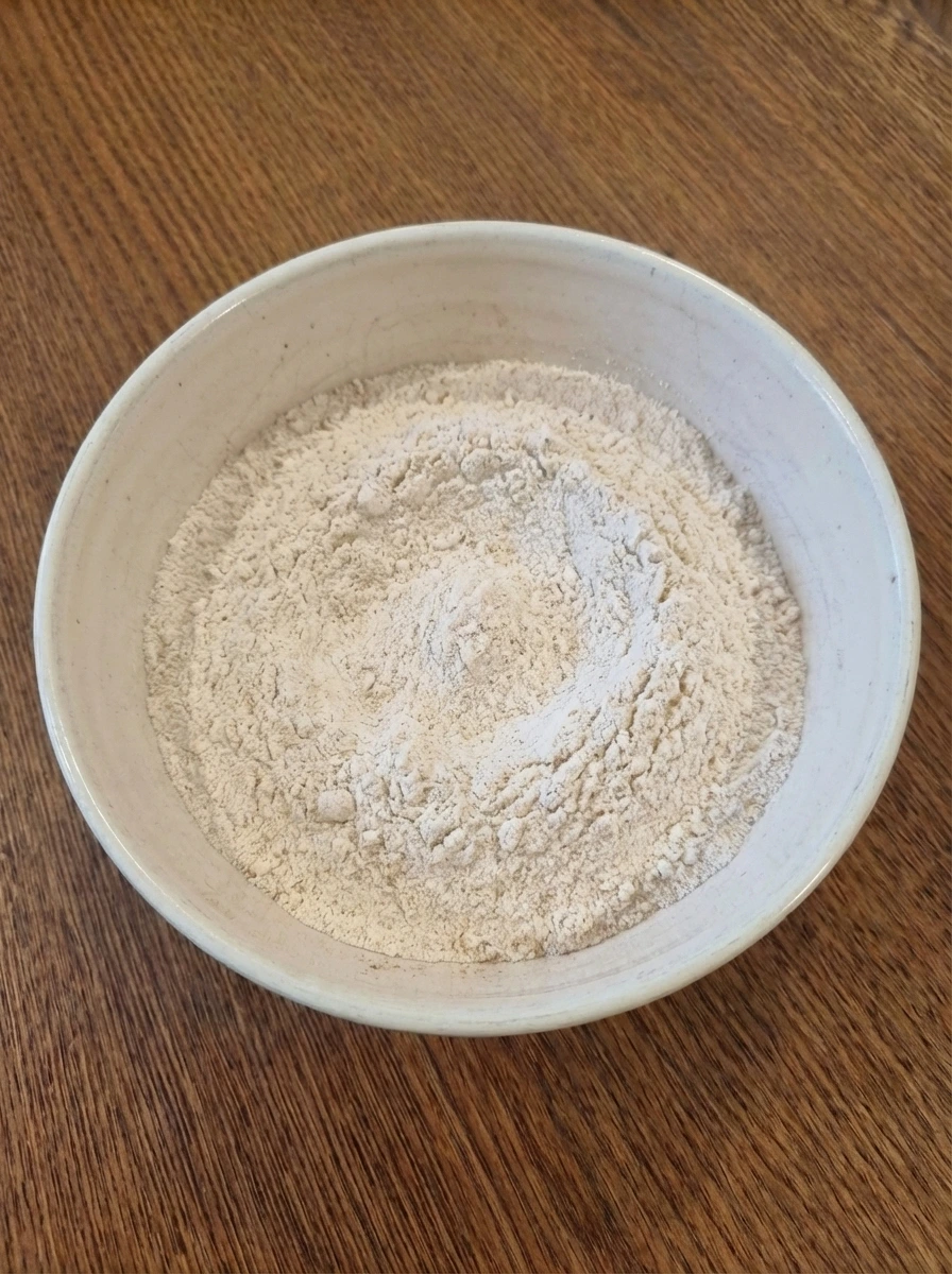 Dry ingredients mixed in a ceramic bowl for strawberry muffins