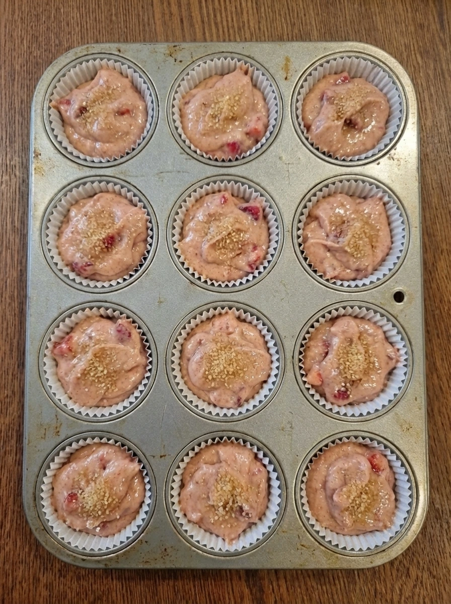 Unbaked strawberry muffin batter in lined muffin cups