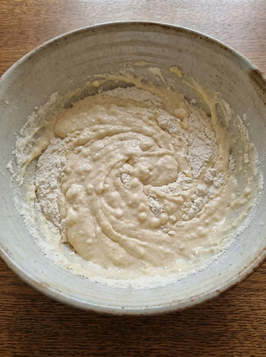 Pancake batter partially mixed with small lumps in a bowl