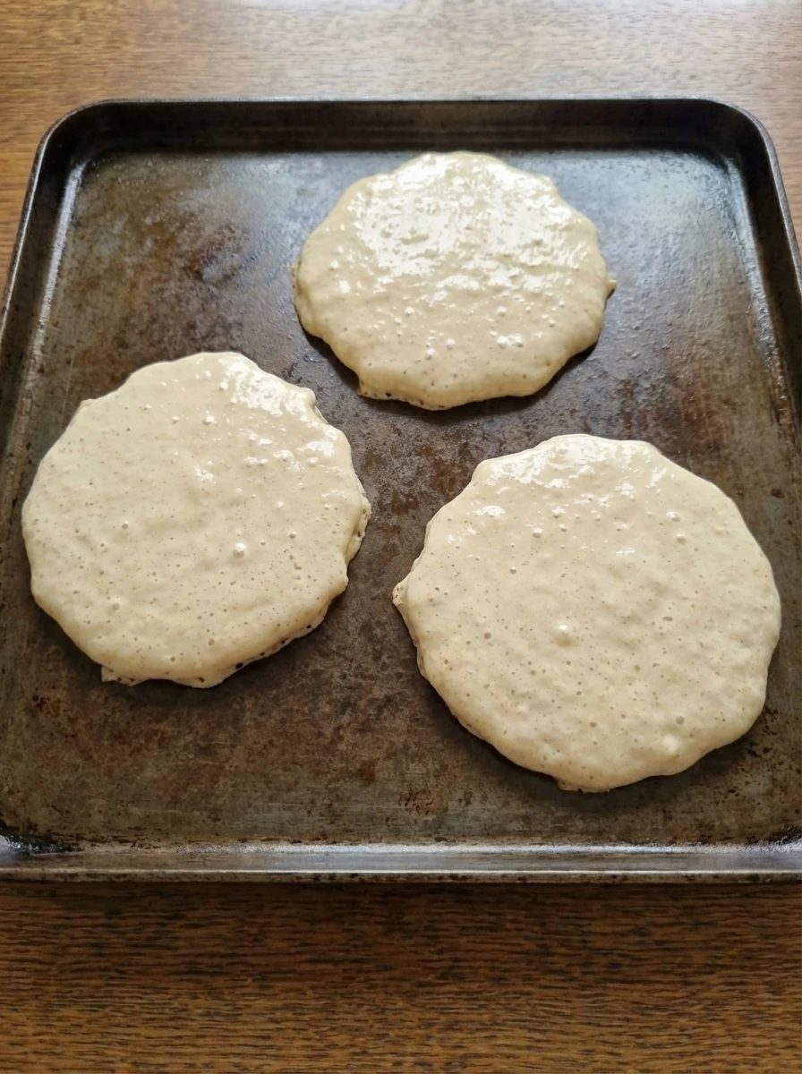 Pancake batter rounds setting with bubbles on top