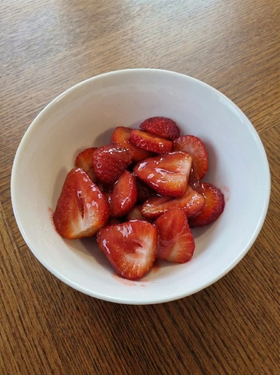 Fresh strawberries folded into thick red glaze in a natural white dish