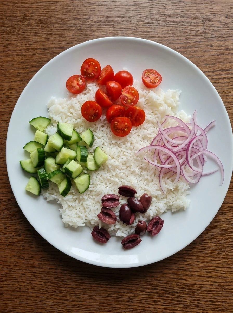 Rice with cucumber tomatoes onion and olives for Greek Chicken Bowl
