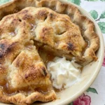 Homemade Apple Pie on a rustic cream ceramic pie plate with golden brown crust and soft spiced apple filling