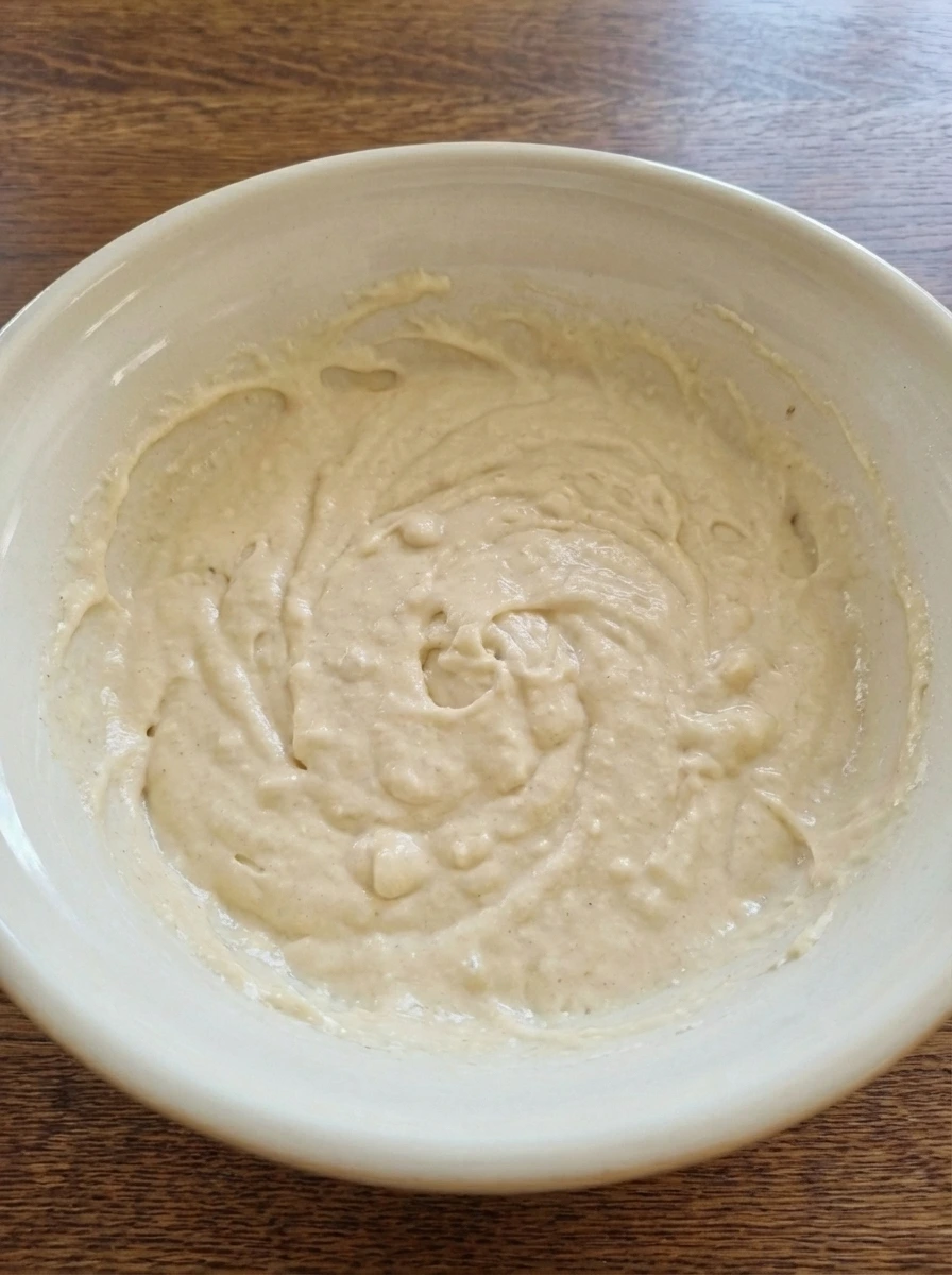Thick waffle batter mixed in a ceramic bowl for Homemade Belgian Waffles