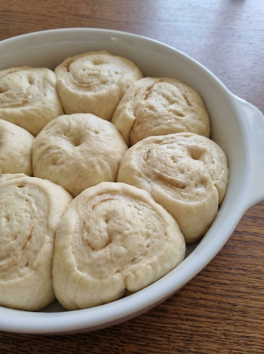 Risen dough for Homemade Cinnamon Rolls in a white dish