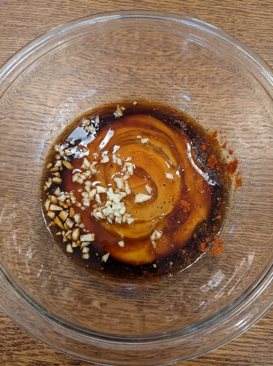 Honey garlic sauce mixed with garlic and seasonings in a bowl
