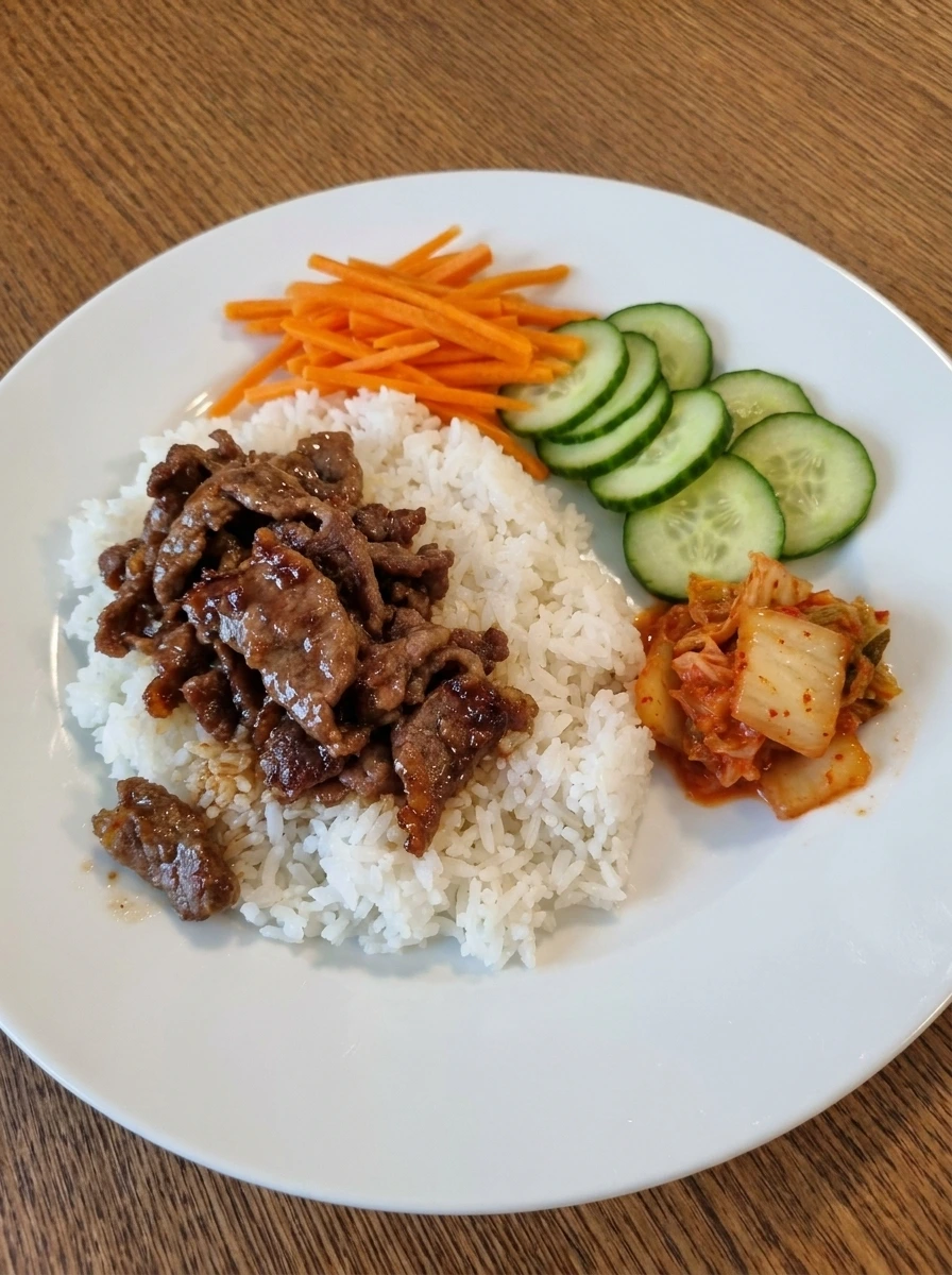 Rice bowls assembled with bulgogi beef carrots cucumbers and kimchi